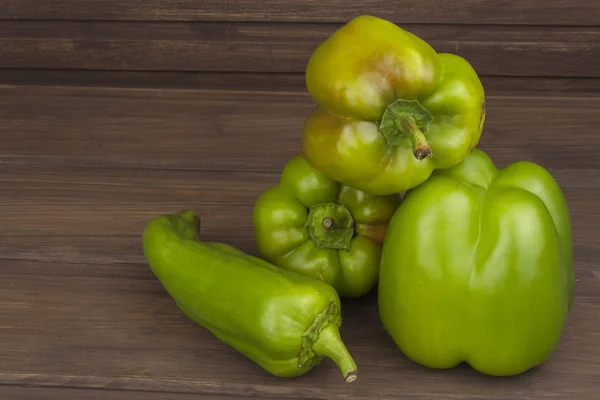 Fargerike paprika på det rustikke trebordet. Nyhøstet paprika på det gamle trebordet. Dyrking av grønnsaker i husholdninger. Forbereder vegetarisk kosthold. Diettmat for idrettsutøvere . – stockfoto