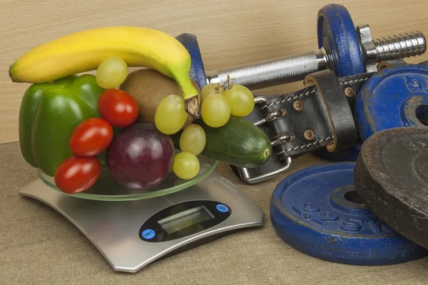 Χρώμιο αλτήρες περιβάλλεται με υγιή φρούτα και λαχανικά σε ένα τραπέζι. Έννοια της υγιείς κατανάλωση και την απώλεια βάρους. Διατροφή για αθλητές. — Φωτογραφία Αρχείου