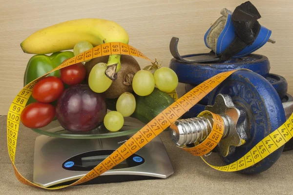 Χρώμιο αλτήρες περιβάλλεται με υγιή φρούτα και λαχανικά σε ένα τραπέζι. Έννοια της υγιείς κατανάλωση και την απώλεια βάρους. Διατροφή για αθλητές. — Φωτογραφία Αρχείου