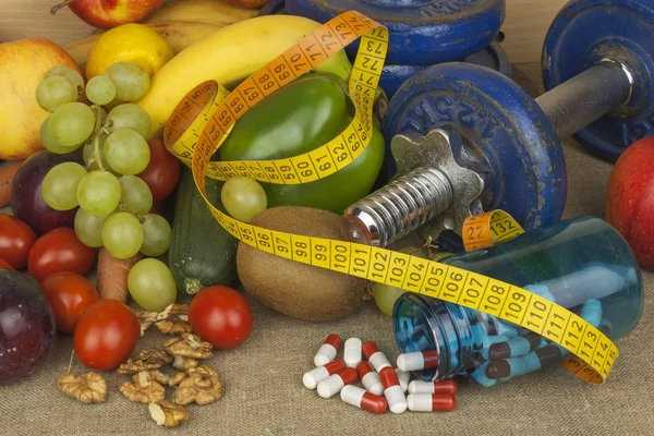 Krom dambıl sağlıklı meyve ve sebzeler bir tablo ile çevrili. Sağlıklı beslenme ve kilo kaybı kavramı. Sporcular için diyet.