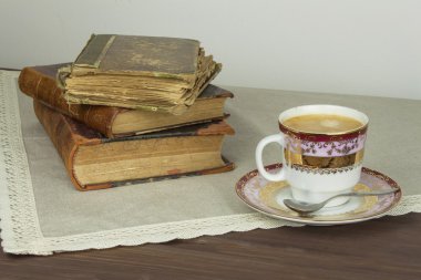 Porselen fincan kahve ve eski kitaplar. Kahveden sonra rahatla. Eski kitap okuma.