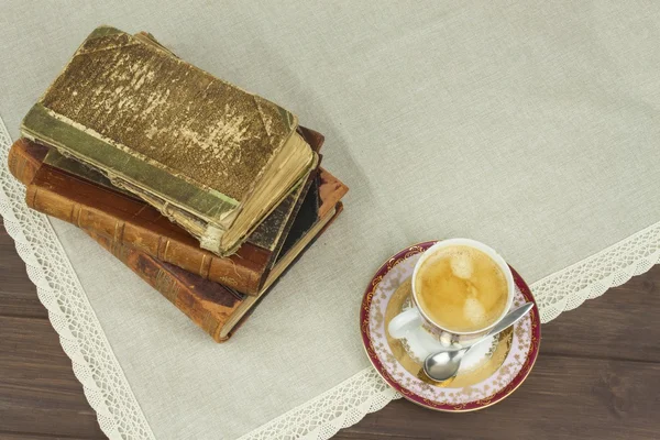 Una taza de café de porcelana y libros viejos. Relájate tomando café. Leyendo libros antiguos . — Foto de Stock