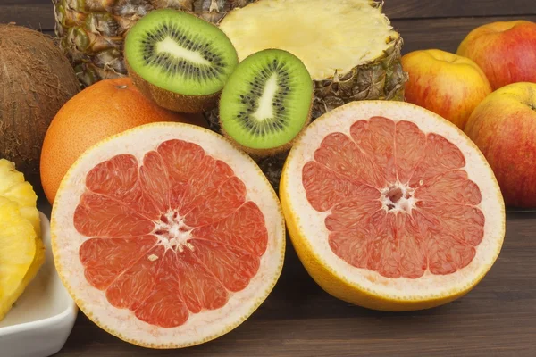 Pomelo rojo y fruta para bajar de peso. Alimentos dietéticos frescos para deportistas. Fruta en una mesa de madera. Composición con variedad de frutas frescas. Dieta equilibrada. Surtido de frutas exóticas . —  Fotos de Stock