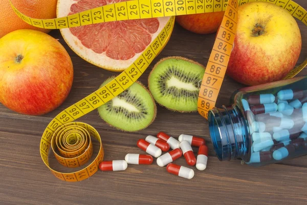 Συμπληρώματα διατροφής για απώλεια βάρους. Κόκκινο γκρέιπφρουτ και φρούτα για την απώλεια βάρους. Φρέσκα διαιτητικά τρόφιμα για αθλητές. Φρούτα σε ένα ξύλινο τραπέζι. Ισορροπημένη διατροφή. Ποικιλία από εξωτικά φρούτα. — Φωτογραφία Αρχείου