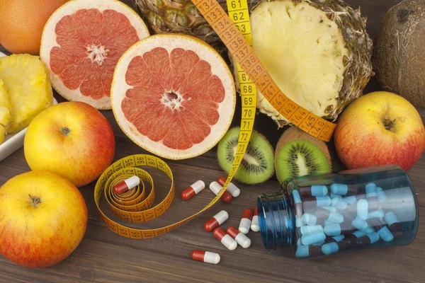 Dietary supplements for weight loss. Red grapefruit and fruit for weight loss. Fresh dietary food for athletes. Fruit on a wooden table.Balanced diet. Assortment of exotic fruits. — Stock Photo, Image