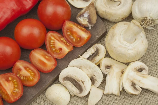 Funghi crudi su un tagliere. Preparazione di Champignons in cucina. Spezie per la preparazione del cibo. Verdure per preparare i pasti — Foto Stock