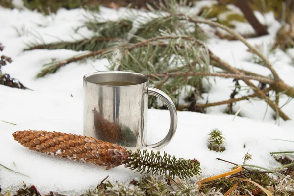 Metal mug of hot tea in snow. Hot drink on a frosty day. Tea for colds. — Stock Photo, Image