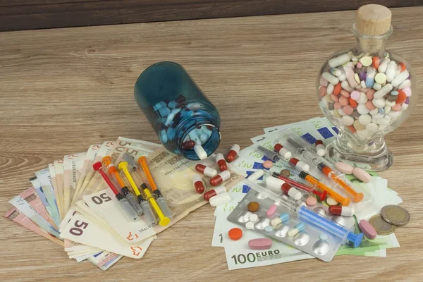 Geld voor een dure behandeling. Geld en pillen. Pillen van verschillende kleuren op geld. Echte eurobankbiljetten. Gezondheidsfinanciering. — Stockfoto