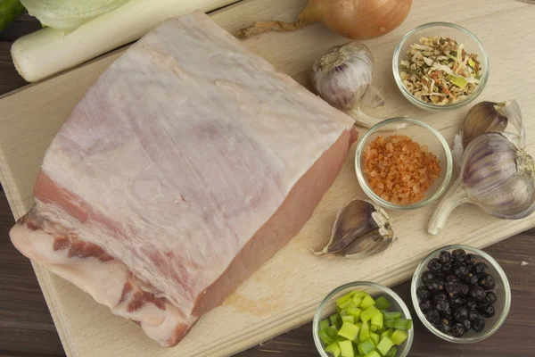 Fresh raw pork on a cutting board with vegetables and spices, preparation of meat for grilling — Stock Photo, Image