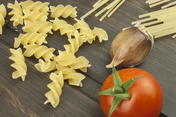 准备菜单。意大利面和蔬菜木制的桌子上。饮食的食品。意大利面、 西红柿、 洋葱、 橄榄油、 罗勒木背景. — 图库照片