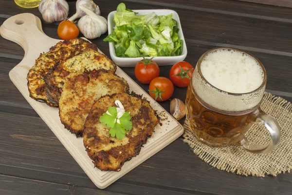 Gebakken aardappel pannenkoeken met knoflook. Traditionele Tsjechische gerechten. Bereiden van zelfgemaakte voedsel. Aardappelpannenkoekjes en bierglazen. — Stockfoto