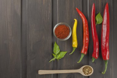 Ahşap mutfak masasında biber. Ev ödevi baharatlı yiyecek. Süslemeleri için belgili tanımlık yemek listesi. Metin için yer. Eski ahşap zemin üzerine taze biber.