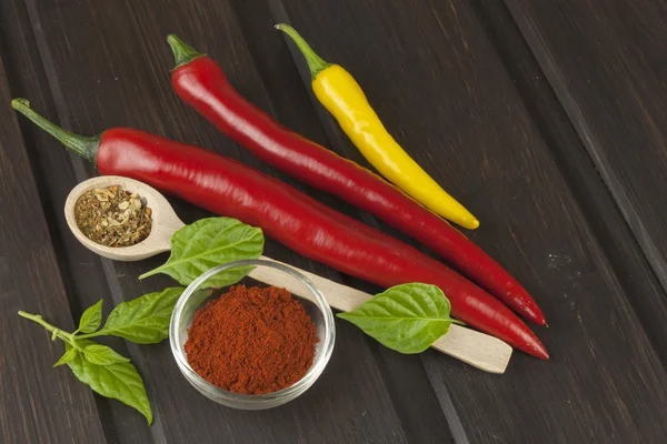 Pimentão em uma mesa de cozinha de madeira. Trabalho de casa comida picante. Decorações para o menu. Lugar para SMS. Chilli fresco no fundo de madeira velha . — Fotografia de Stock