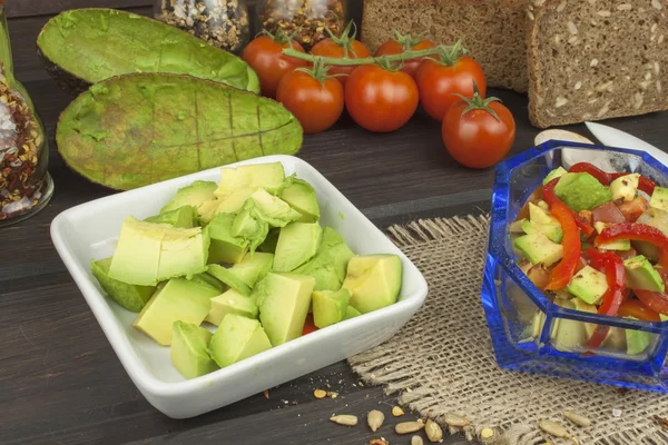 Beredning av kosten avokadosallad. Färsk mogen avokado på trä bakgrund. Mat bakgrund med färska ekologiska avokado. Avokado på en trä bakgrund — Stockfoto