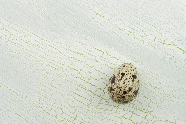 Перепелиные яйца трескались на белом фоне. Перепелиные яйца на старом потрескавшемся деревянном фоне . — стоковое фото