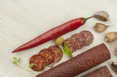 Çatlak gölgeli arka planda farklı baharatlı salam çeşitleri. Ev kutlamalarını hazırlıyorum. Ziyaret için içecekler. Sosis üretimi.