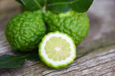 Taze bergamot meyvesi, Kaffir limonu, Citrus bergamia ve ahşap masa üzerinde yaprak / Slice bergamot citrus ana petrol kavramı