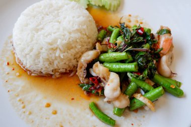Bahçe fasulyesi, kızarmış deniz ürünleri, karides, fesleğen, pirinç, baharatlı Tayland yemeği, salatalık ve acı biber.