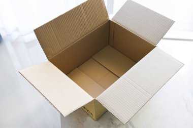 Yer zeminindeki karton kutuyu aç, boş bir karton kutu veya paket kutusunun yüksek açılı görünümünü aç
