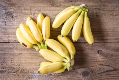 Tahta zemin üzerinde olgun muzlu tropikal meyve, taze muz