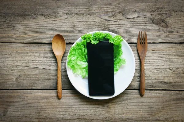 Service food delivery order online smart phone laying on plate and on the rustic wooden table with lettuce vegetables, Call for delivery mobile food ordering concept