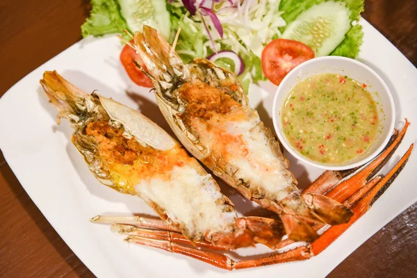 Grilled shrimp cut half with fresh vegetable and seafood sauce, Giant river prawn shrimp grilled serve on white plate
