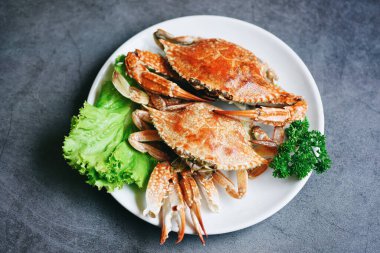 Restoranda yengeç pişirme, haşlama ya da haşlama Mavi yüzme yengeci okyanus gurmesi salata salatasıyla marul, üst manzara. 