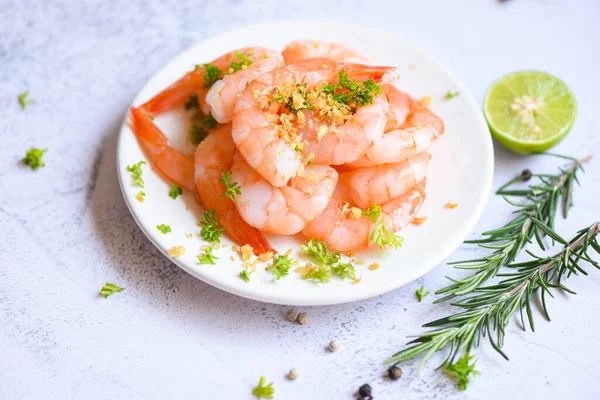 Garlic shrimp peeled on white plate background dining table food, Fresh shrimps prawns seafood lemon lime with herbs and spice