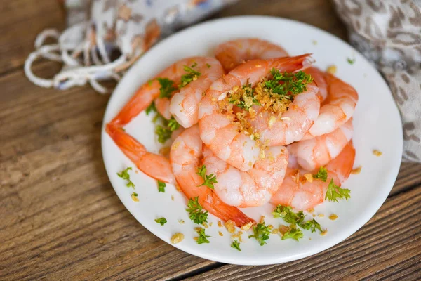 Garlic shrimp peeled on white plate wooden background dining table food, Fresh shrimps prawns seafood  with herbs and spice