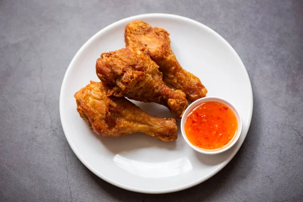 Fried chicken leg on plate with chicken dipping sauce, crispy fried chicken in a table food