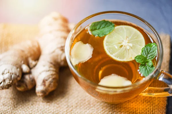 Ginger and lemon fresh cocktail, Hot ginger juice in glass and mint with slices ginger root herbal juice tea