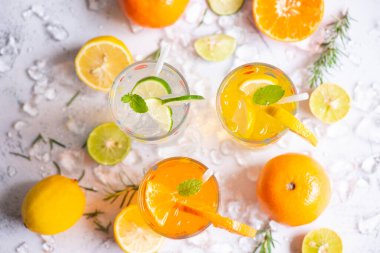 Renkli yaz içecekleri sulu, egzotik yaz içecekleri soğuk içecekler taze meyve bardakları buzlu ev yapımı kokteyl çayı limonlu, portakallı ve nane yapraklı.