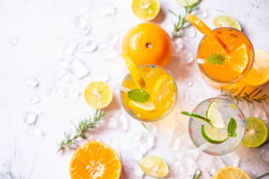 Renkli yaz içecekleri sulu, egzotik yaz içecekleri soğuk içecekler taze meyve bardakları buzlu ev yapımı kokteyl çayı limonlu, portakallı ve nane yapraklı.