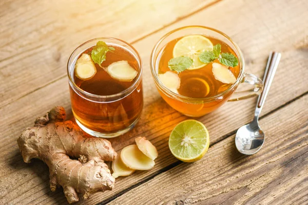 Ginger and lemon fresh cocktail, Hot ginger juice in glass and slices ginger root herbal juice tea