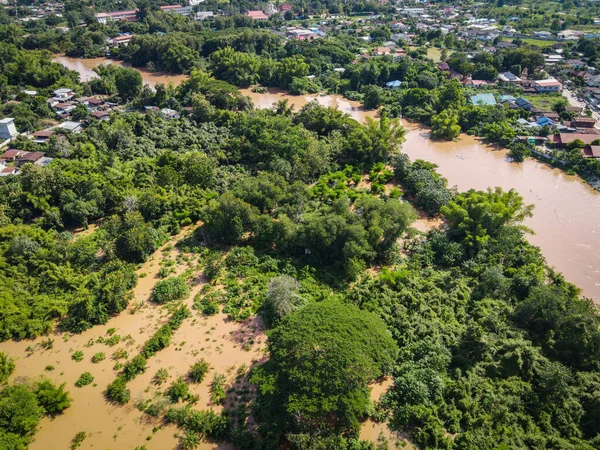 Aerial view river flood village countryside Asia and forest tree, Top view river with water flood from above, Raging river running down jungles lake flowing wild water after the rain