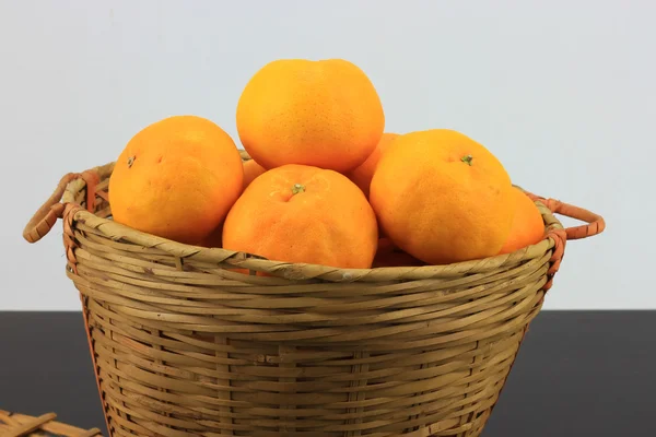Tumpukan jeruk mandarin dalam keranjang rotan — Stok Foto