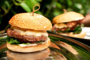 Lezzetli taze hamburger, pirzola, marul ve peynir bir kafede masanın üstünde..