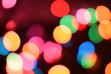 Kamera ve lens Bokeh 'ten oluşan parlak ve renkli ışık çemberleri. Noel perisi ışıkları bulanık bir etki yaratarak odağını bozdu. Tasarım için arkaplan.
