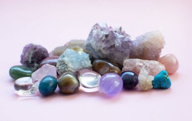 Çalkalanmış ve pürüzlü değerli taşlar ve çeşitli renklerde kristaller. Ametist, gül kuvars, agate, apatit, aventurine, olivine, turkuaz, aquamarine, kaya kristali. Seçici odak.