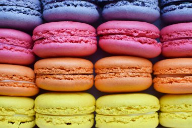 Arka plan olarak gökkuşağı renginde bademli kurabiyeler. Doldurulmuş lezzetli Fransız kurabiyeleri.