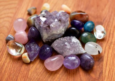 Çeşitli renklerde mücevherler. Amethyst, rose quartz, agate, apatite, aventurine, olivine, turkuaz, aquamarine, ahşap zemin üzerinde kaya kristali