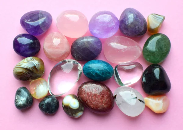 各种颜色的宝石 紫水晶 玫瑰石英 磷灰石 复仇石 橄榄石 绿松石 水蓝石和粉色背景的岩石晶体 — 图库照片