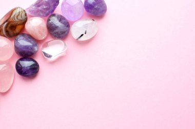 Pembe arka planda güzel değerli taşlar. Ametist ve gül kuvars. Yarı değerli taşların büyük kristalleri..