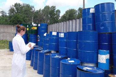 RUSSIA, SAINT PETERSBURG 02 Temmuz 2019 Beyaz önlüklü bir kadın mühendis metal varillerin kayıtlarını tutar