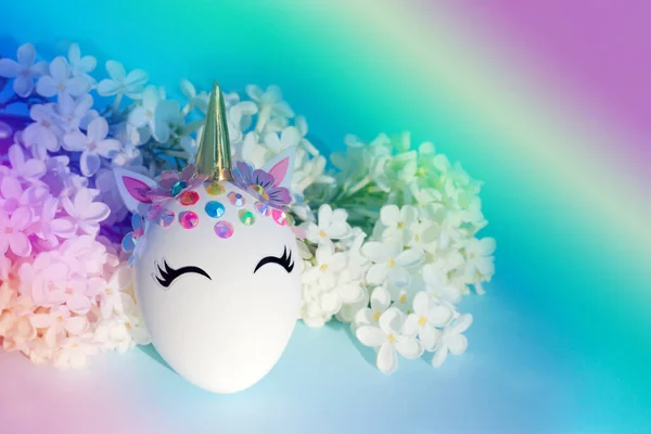 Kreatywne Dekoracyjne Jajko Wielkanocne Postaci Jednorożca Białymi Delikatnymi Kwiatami Tle — Zdjęcie stockowe