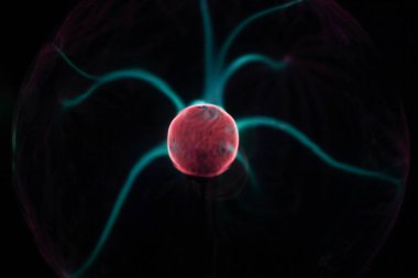 Tesla 'nın bobininde yüksek voltaj yayı. Plazma lambası. Elektrik enerjisinin soyut kavramı. Cam kürenin merkezinden yıldırımlar geliyor..