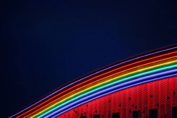 Rainbow of LED strips. decor on the shopping center. multicolored wave against a Dark sky — Stock Photo, Image