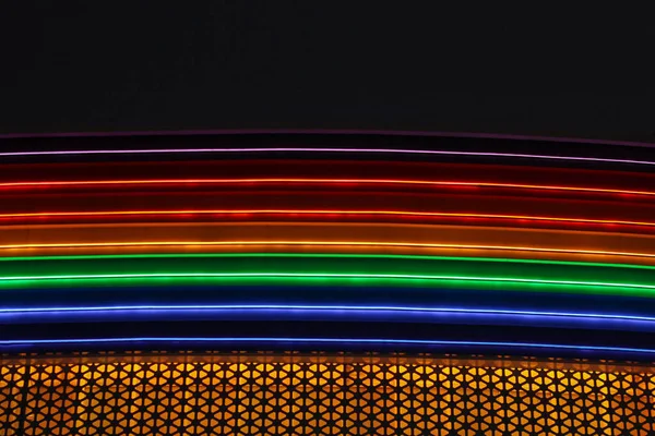 Regenboog van LED strips. decor op het winkelcentrum. veelkleurige golf tegen een donkere lucht Rechtenvrije Stockfoto's