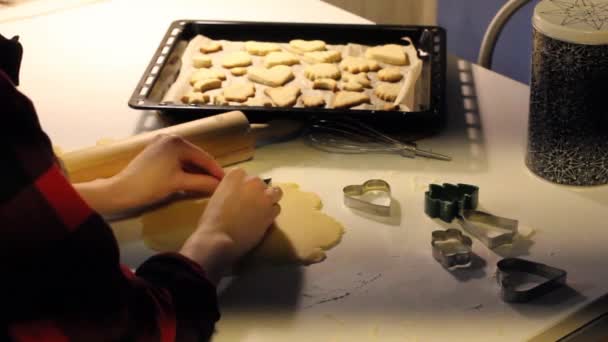 Zelfgemaakte koekjes koken. een vrouw snijdt een koekjessnijder uit in de vorm van een kerstboom. kerststemming — Stockvideo