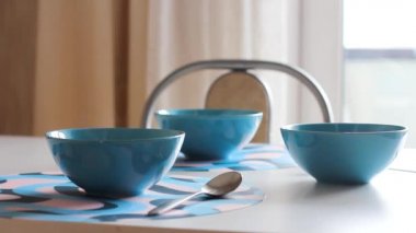 Masada üç mavi tabak sıcak yulaf lapası ya da buharda pişmiş çorba..